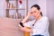 Beautiful young brunette woman confused receives news by the smartphone sitting on the sofa at home.