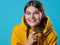 A beautiful young brunette in a yellow oversize hoodie, a positive student in a bright outfit