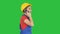 Beautiful young builder woman wear a yellow safety helmet making a call on a Green Screen, Chroma Key.
