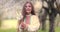 Beautiful young bulgarian girl in blooming spring orchard of apple trees wearing ethnic folklore traditional costume video