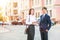 Beautiful young business woman and handsome businessman in formal suits are using a digital tablet in city background