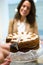 Beautiful young businesswoman buying portion of delicious homemade carrot cake in the coffee shop.