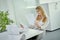 Beautiful young businesswoman looks at documents at the desk