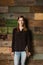 Beautiful young businesswoman standing against a wooden wall