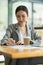 Beautiful young businesswoman using laptop and doing some paperwork