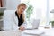 Beautiful young businesswoman writing and reviewing papers in the office.