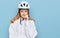 Beautiful young caucasian girl wearing bike helmet serious face thinking about question with hand on chin, thoughtful about