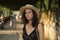 Beautiful young caucasic woman with a hat smiling to the camera in the streets of Spain