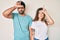 Beautiful young couple of boyfriend and girlfriend together making fun of people with fingers on forehead doing loser gesture
