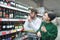 A beautiful young couple chooses wine in the alcohol department of the supermarket. Family shopping at the store