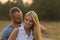 Beautiful young couple in the field next to the motorcycle