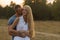 Beautiful young couple in the field next to the motorcycle