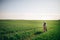 Beautiful young couple gently hugging in sunshine in spring green field. Happy family embracing in green meadow with fresh grass