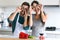 Beautiful young couple having fun and playing with peppers slices on the eyes in the kitchen at home