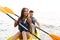 Beautiful young couple kayaking on lake together