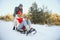 Beautiful young couple in love having fun on a winter vacation in mountains, boyfriend pushing girlfriend on a sled, enjoying