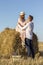 Beautiful young couple in love hugging in field near hay bale. Holidays in countryside concept.