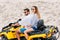 beautiful young couple in sunglasses riding all-terrain vehicle