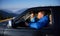 Beautiful young couple travelling in the car in mountains.