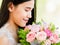 A beautiful young cute black long hair Asian woman holding a sweet color roses bouquet and closed eyes with happy and deep love