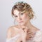 Beautiful young elegant sweet girl in the image of a bride with hair and flowers in her hair , delicate wedding makeup