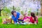 Beautiful young family with kids having picnic outdoors