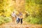 Beautiful young family on a walk in autumn forest.