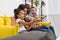 beautiful young family watching tv together