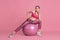 Beautiful young female athlete practicing on pink studio background, monochrome portrait