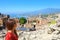 Beautiful young female model in the ruins of the ancient Greek theater in Taormina with the Etna volcano and Ionian sea on the