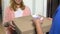 Beautiful young female opening door and taking pizza paying courier for delivery