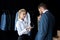 beautiful young female seller showing cufflinks to businessman