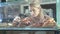 Beautiful young female seller working in the confectionery store. Close-up of fresh pastries on a vitrine