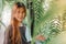 Beautiful young female smiling inside a garden full of plant leaves