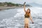 Beautiful young Filipina woman,playfully paddling in the shallow waves of the long sandy beach at Iba,Zambales,Luzon,Philippines