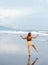 Beautiful young Filipina woman,playfully paddling in the shallow waves of the long sandy beach at Iba,Zambales,Luzon,Philippines