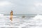 Beautiful young Filipina woman,playfully paddling in the shallow waves of the long sandy beach at Iba,Zambales,Luzon,Philippines