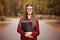 Beautiful young financial businesswoman in glasses looking at camera and smiling while standing in park