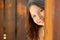 Beautiful young girl behind the wooden door