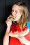 A beautiful and young girl bites a fresh, delicious and juicy watermelon. She is very hungry and wants to eat it.