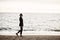 A beautiful young girl in a black suit, retro-image with a preceding, walks on the beach