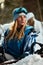 Beautiful young girl in a blue ski suit and helmet. On the head are glasses for snowboarding. Snow-covered mountain