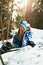 Beautiful young girl in a blue ski suit and helmet. On the head are glasses for snowboarding. Snow-covered mountain