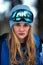 Beautiful young girl in a blue ski suit and helmet. On the head are glasses for snowboarding. Snow-covered mountain