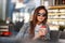 Beautiful young girl with coffee in sunglasses sits