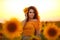 Beautiful young girl enjoying nature on the field of sunflowers at sunset. Summertime. Attractive brunette woman with long healthy