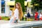 Beautiful young girl examines passers by fountain in the park