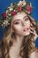 Beautiful young girl with a floral ornament in her hair on a blue background. Woman in wreath of flowers.Beauty Face. Fashion