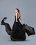 Beautiful young girl in flying black dress. Flowing fabric. Light black fabric flying in the wind