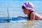 Beautiful young girl freelancer escapes from the heat at sea and working remotely with netbook in cool water. Horizontal image